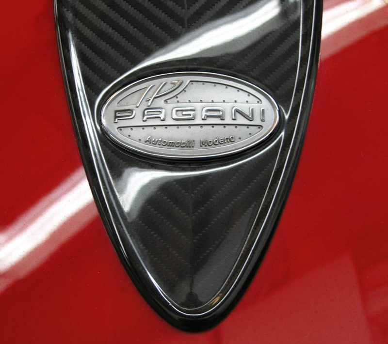 Black and Silver Pagani Automobili Modena emblem on red background
