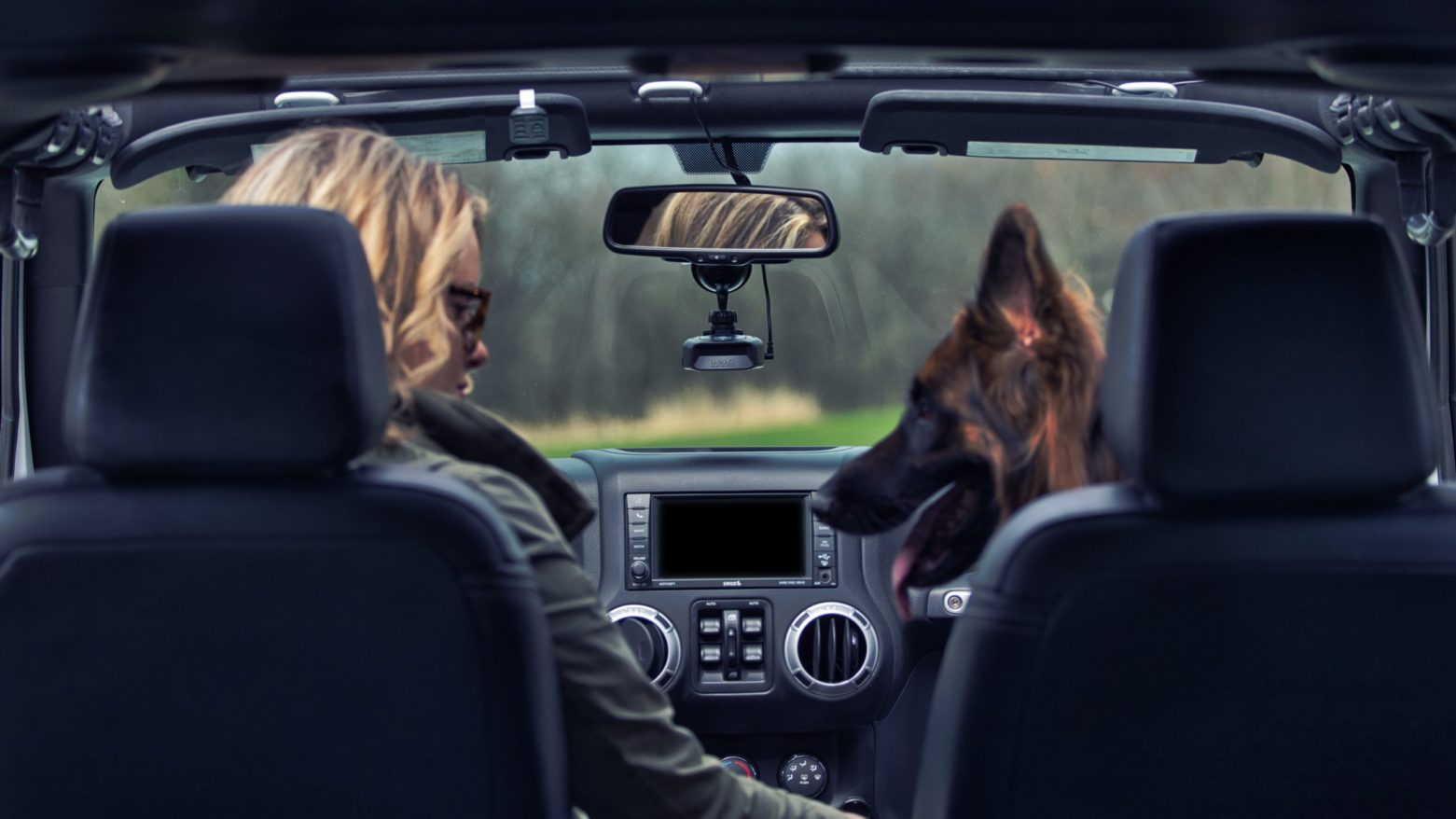 Woman in Jeep Wrangler driving with K40 Platinum100 and her German Shepard